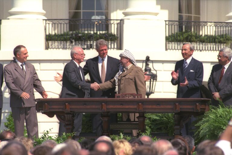 The Oslo Accords GPO - Avi Ohayon P.M. Yitzhak Rabin shaking hands with PLO chairman Yasser Arafat (R) on white house lawn as U.S. Pres. Bill Clinton looks on.